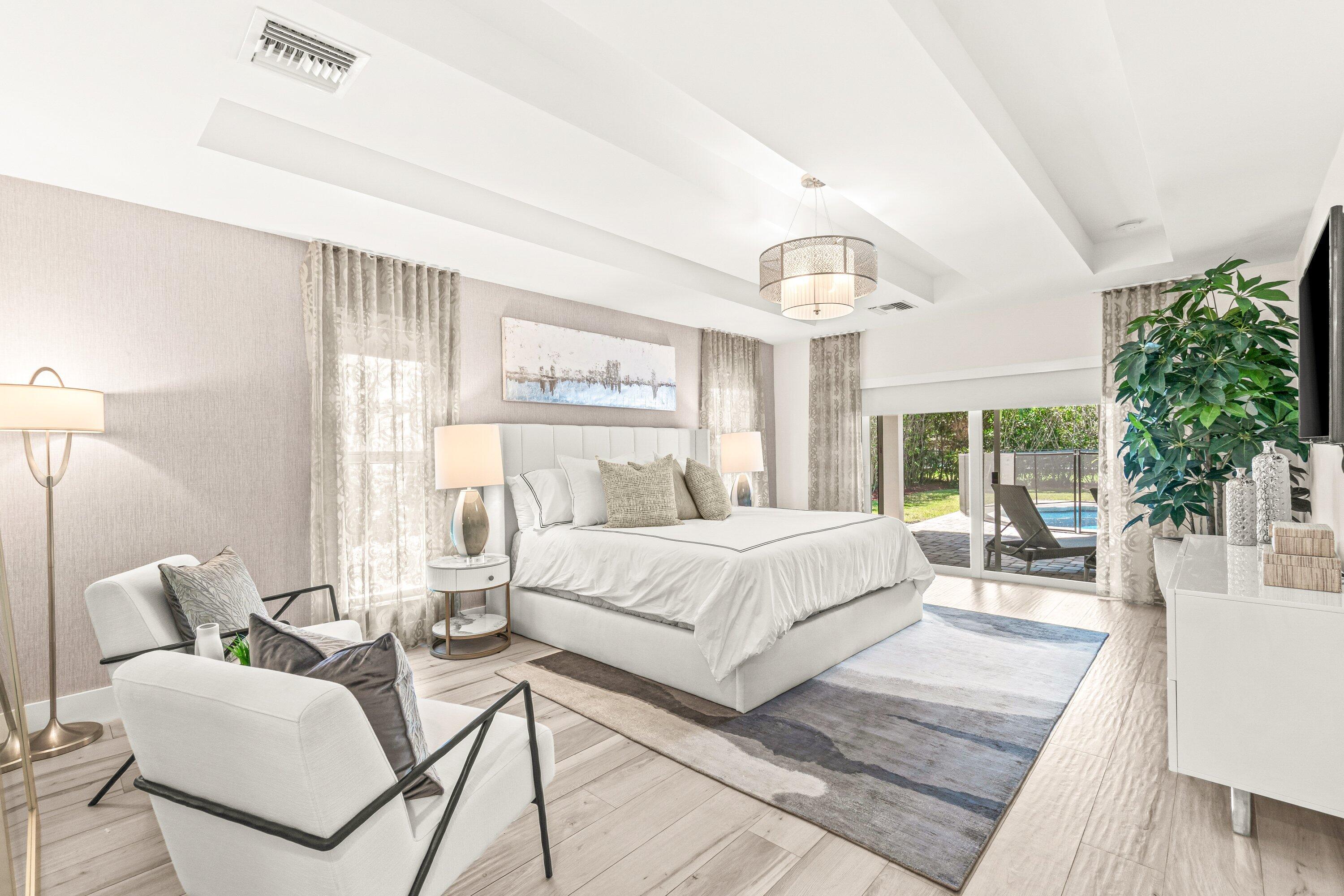 2367 Queen Palm Road Boca Raton, FL 33432 - Photo 23 of 44 a spacious bedroom with a large bed and a chandelier