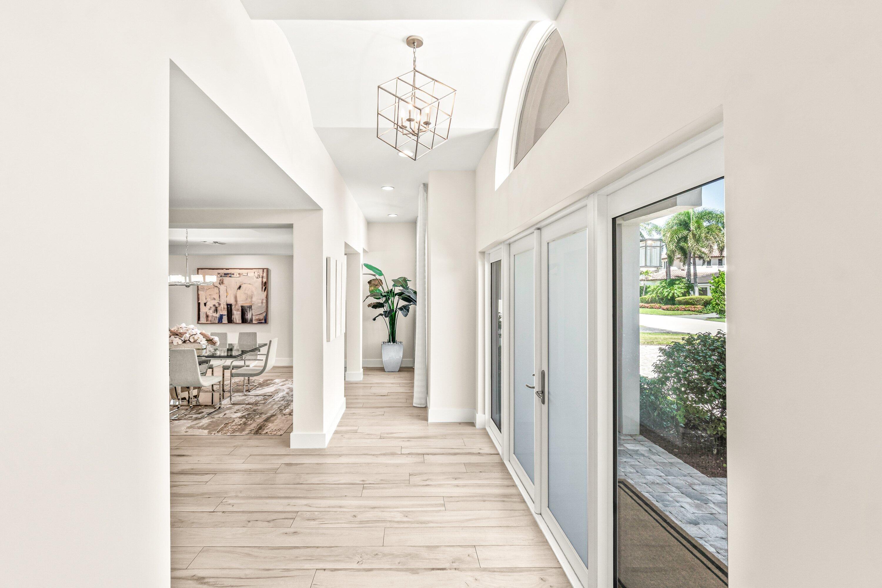 2367 Queen Palm Road Boca Raton, FL 33432 - Photo 5 of 44 a view of a hallway view with wooden floor and a chandelier