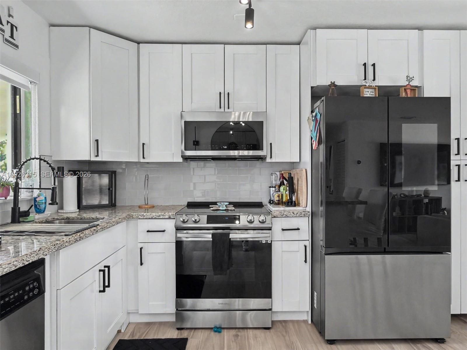 10762 Southwest 145th Street Miami, FL 33176 - Photo 10 of 28 a kitchen with stainless steel appliances granite countertop a stove a refrigerator and a granite counter tops