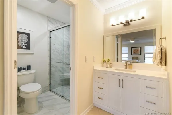 a bathroom with a sink a toilet and shower