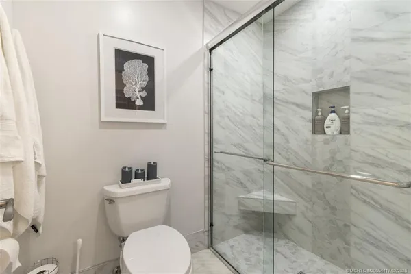 a white toilet sitting next to a bathroom sink
