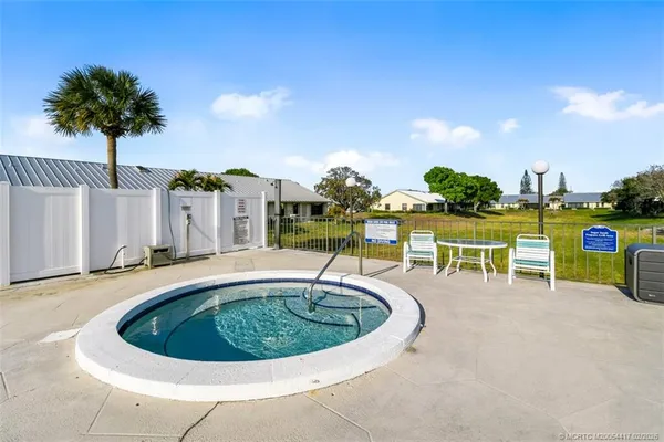 a view of a swimming pool with a patio and a yard