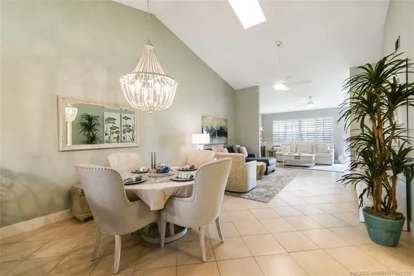 a living room with furniture a chandelier and a dining table