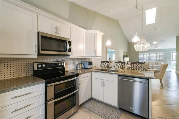 a kitchen with stainless steel appliances a stove microwave and sink