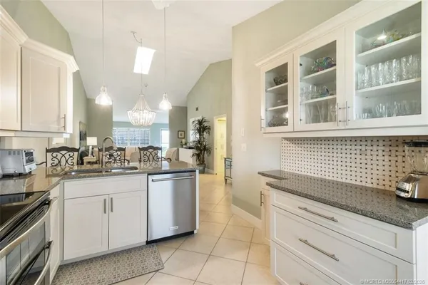 a kitchen with granite countertop white cabinets and white appliances