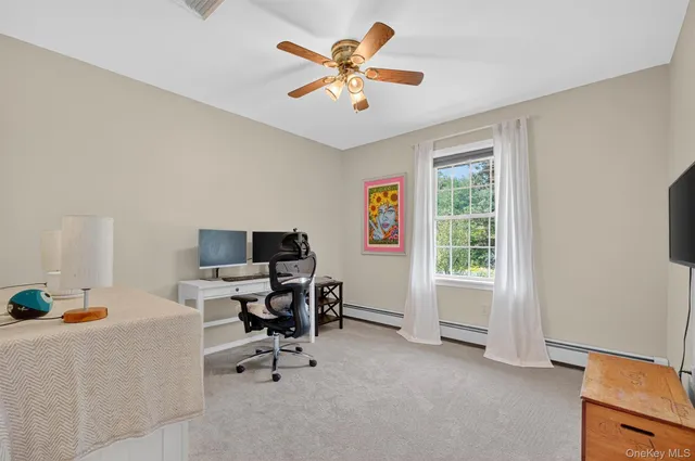 a view of a workspace with furniture and a window