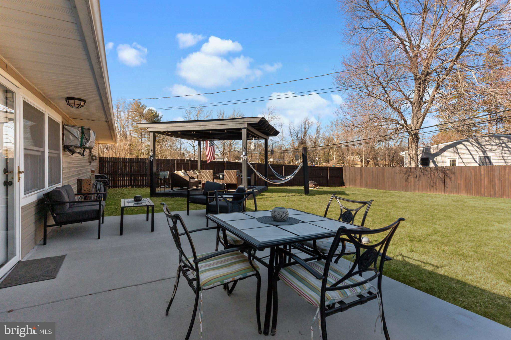 56 Old Pond Road Levittown, PA 19057 - Photo 15 of 20 a view of a patio with couches table and chairs with wooden floor and fence