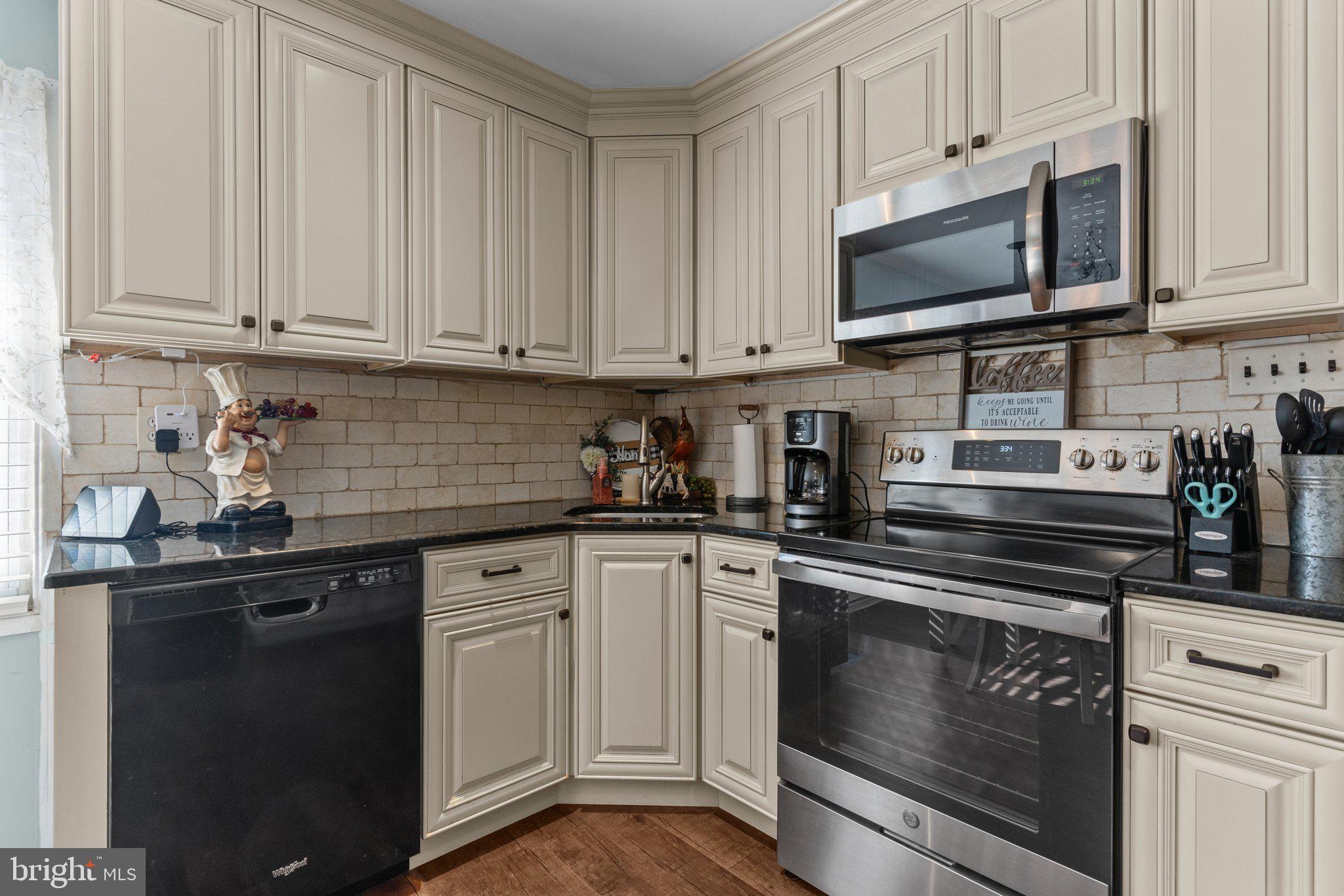 56 Old Pond Road Levittown, PA 19057 - Photo 6 of 20 a kitchen with white cabinets and black appliances