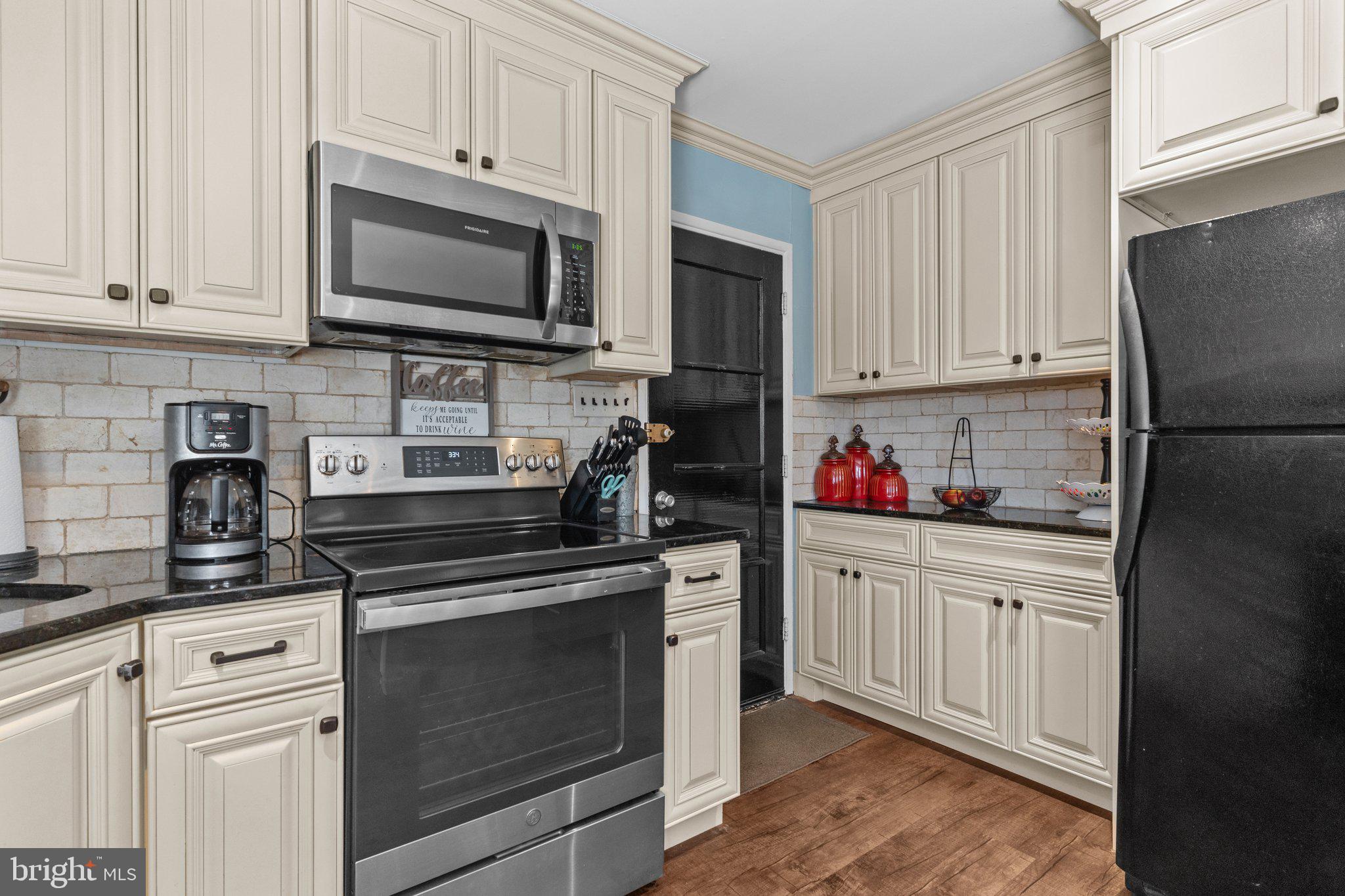 56 Old Pond Road Levittown, PA 19057 - Photo 7 of 20 a kitchen with granite countertop white cabinets and stainless steel appliances