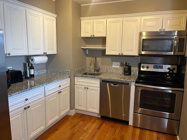 a kitchen with stainless steel appliances granite countertop a stove a sink and a microwave
