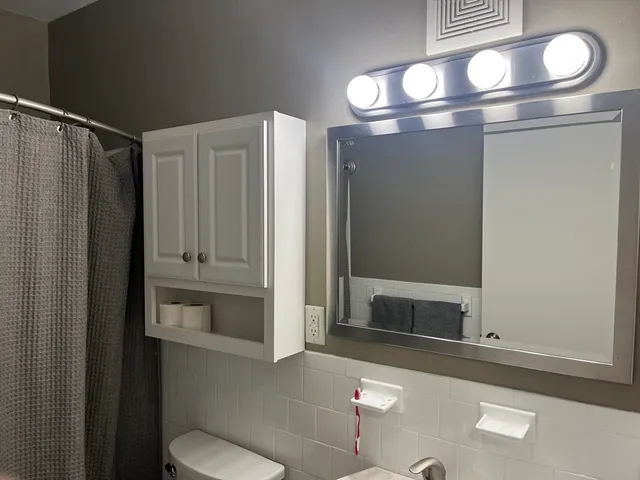 a bathroom with a sink mirror vanity and toilet