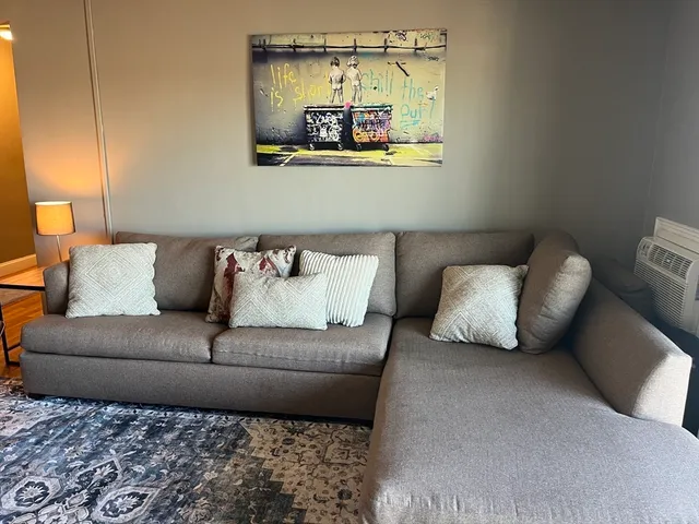 a living room with furniture and painting on the wall