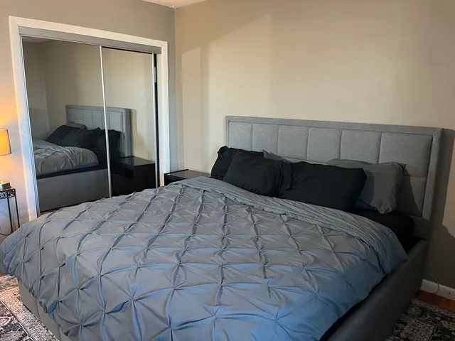 a bedroom with a bed and a mirror