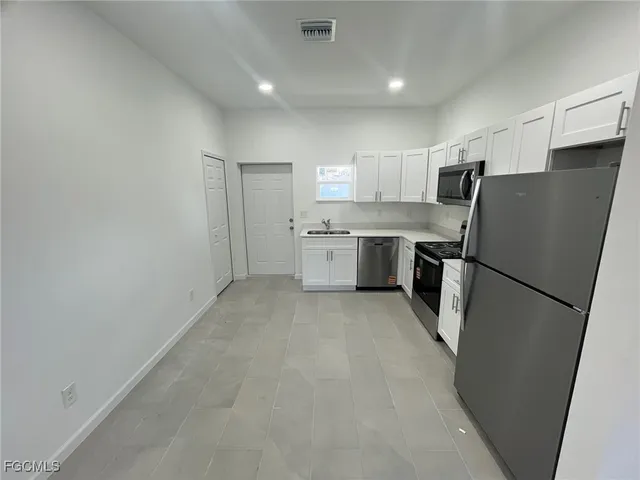 a kitchen with a refrigerator sink and stove