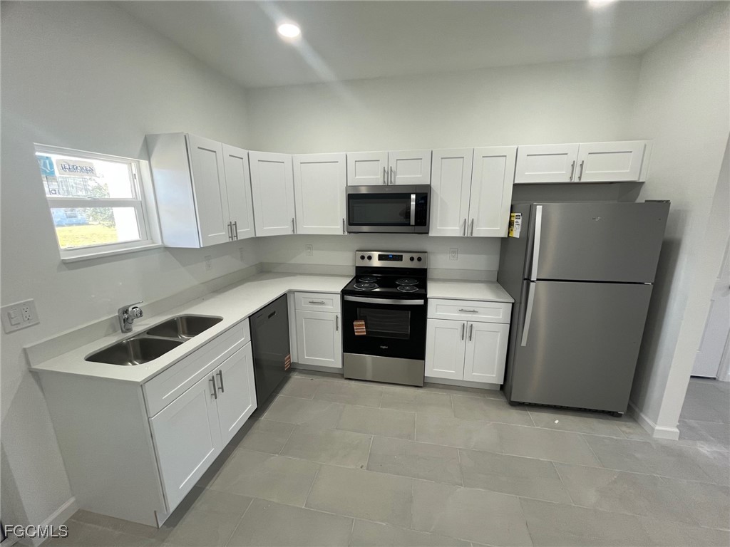 3307 50th Street West Lehigh Acres, FL 33971 - Photo 4 of 15 a kitchen with a refrigerator sink and stove