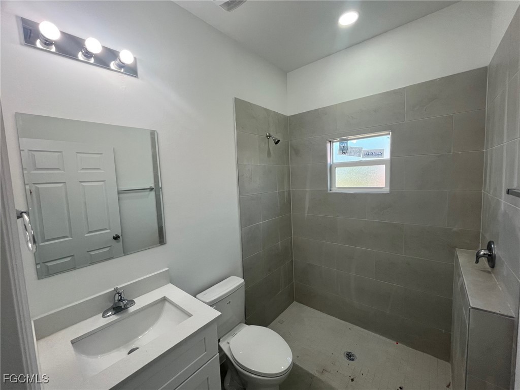 3307 50th Street West Lehigh Acres, FL 33971 - Photo 7 of 15 a bathroom with a sink a toilet and shower