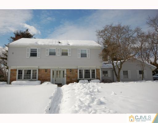 a front view of a house with a yard covered in snow