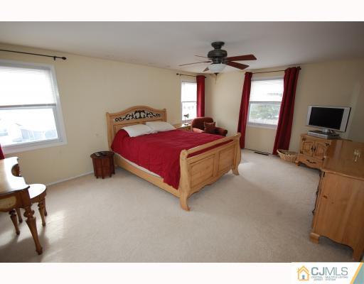 4 Edgewood Road Old Bridge, NJ 07747 - Photo 6 of 7 a living room with a bed furniture a chandelier and a window