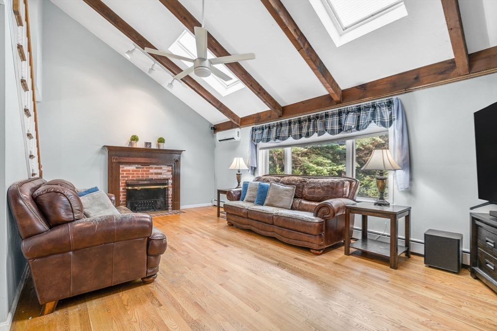 3 Erin Lane Norfolk, MA 02056 - Photo 13 of 37 a living room with furniture a fireplace and a flat screen tv
