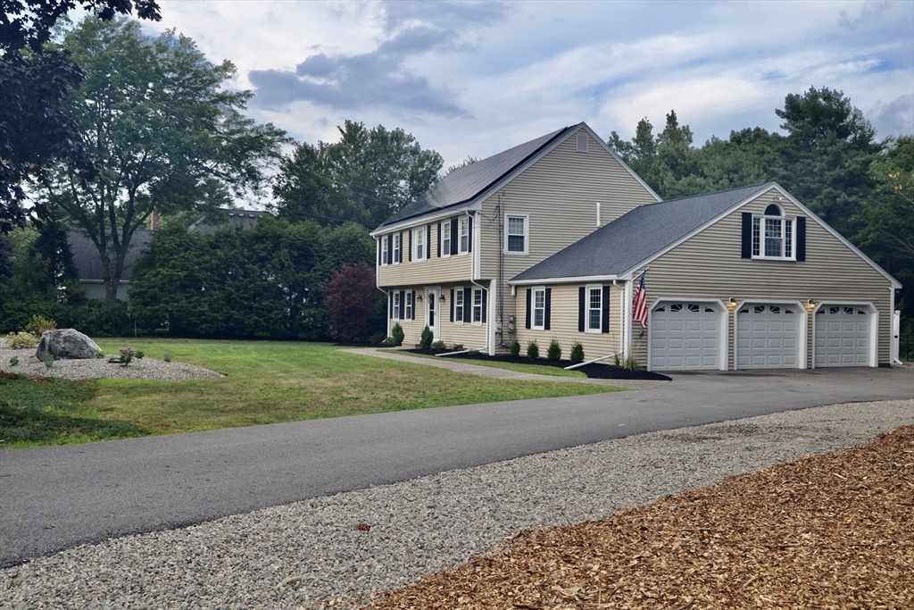 3 Erin Lane Norfolk, MA 02056 - Photo 3 of 37 a front view of a house with a yard and garage