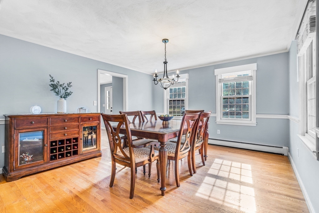 3 Erin Lane Norfolk, MA 02056 - Photo 7 of 37 a dining room with furniture a chandelier and wooden floor