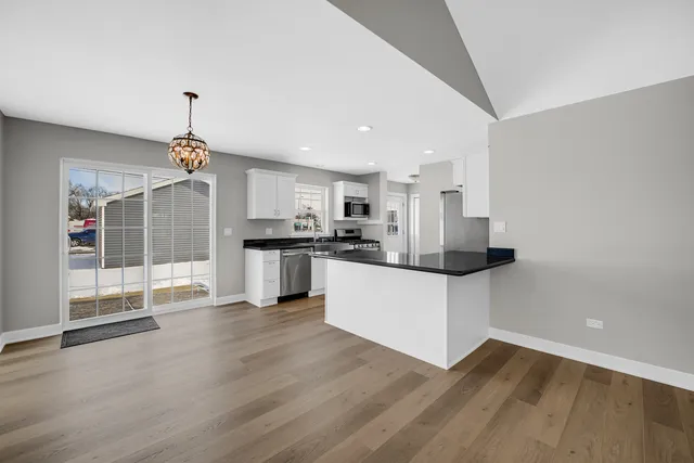 a kitchen with stainless steel appliances granite countertop a refrigerator and a stove top oven