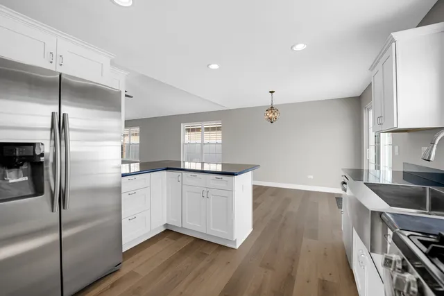 a kitchen with granite countertop a refrigerator and a sink