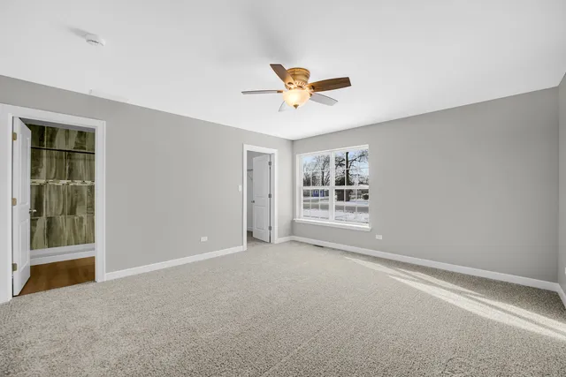 a view of a livingroom with a ceiling fan and window