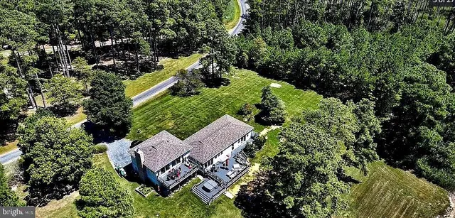 a roof deck with table and chairs with wooden floor