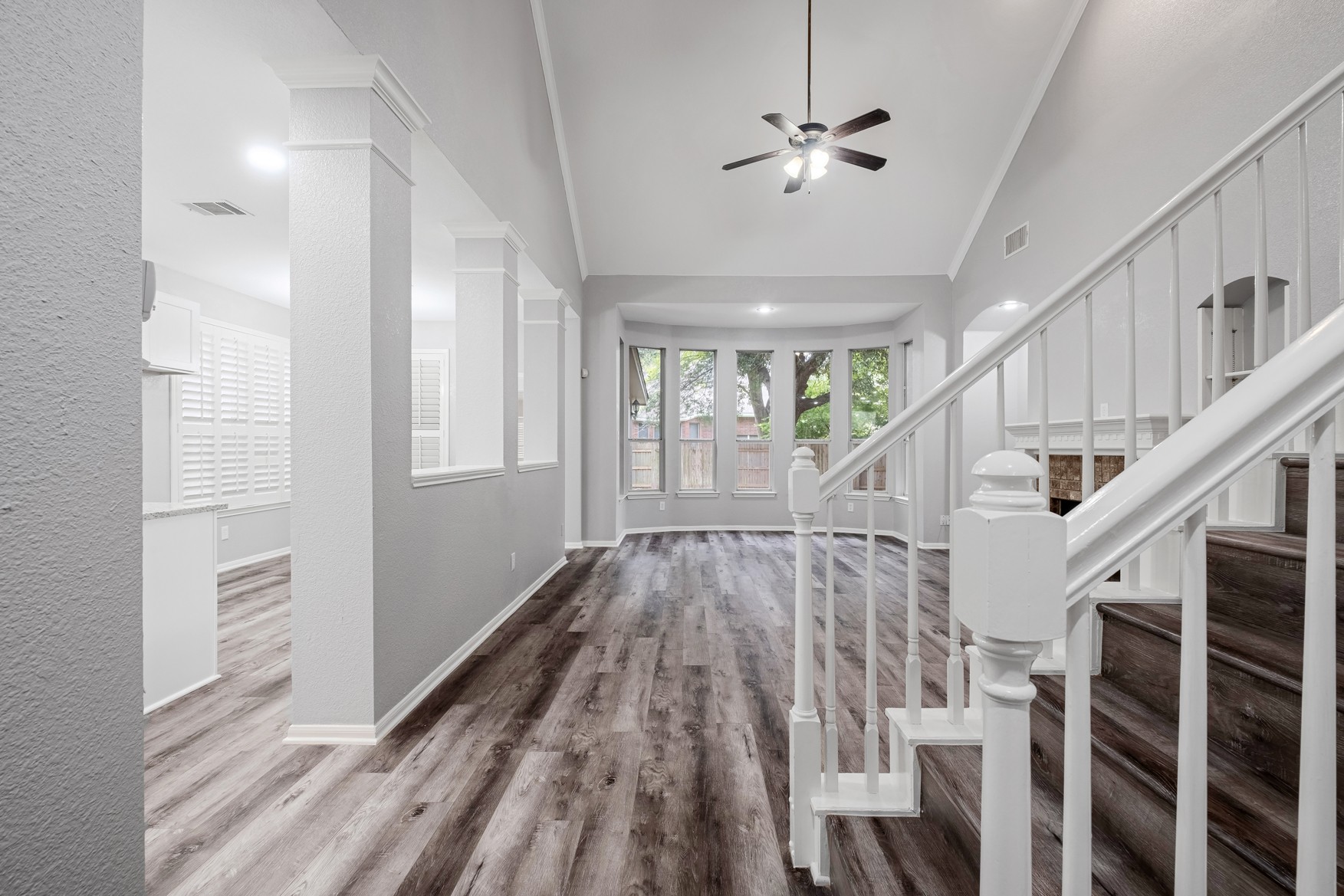 A spacious living area with soaring vaulted ceilings and rich wood flooring.