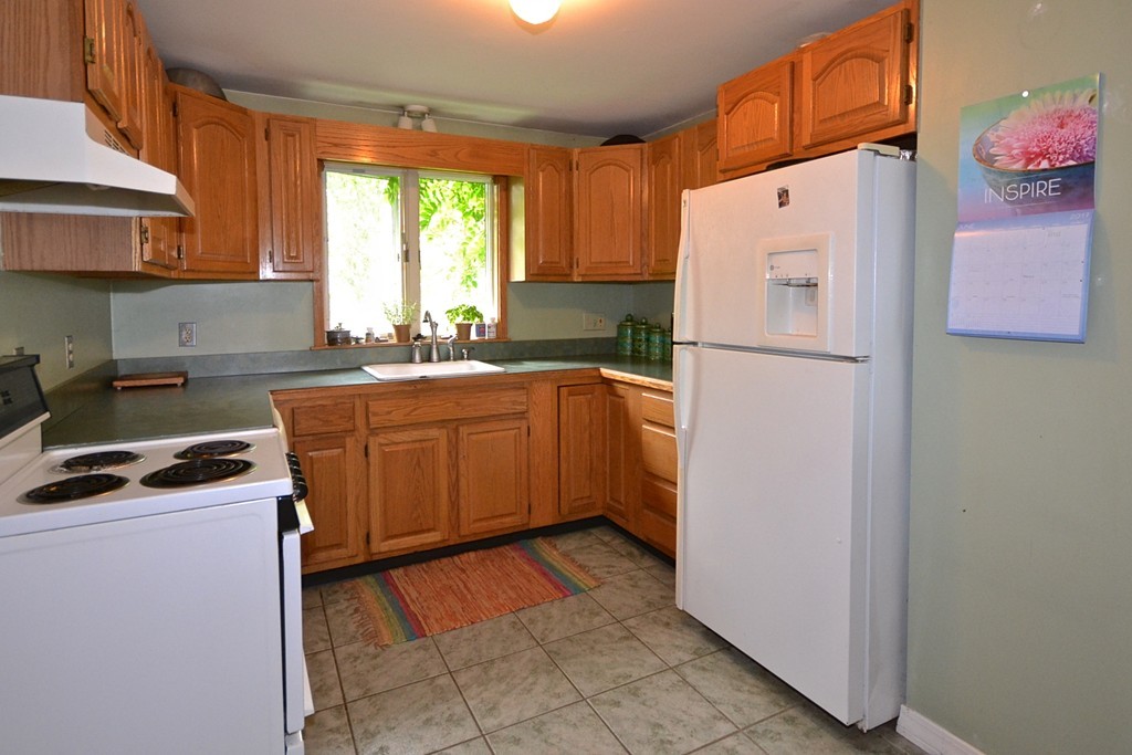 16 Harvard Street Fairhaven, MA 02719 - Photo 5 of 14 a kitchen with a sink a refrigerator a window and cabinets