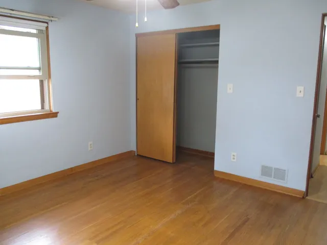an empty room with windows and closet