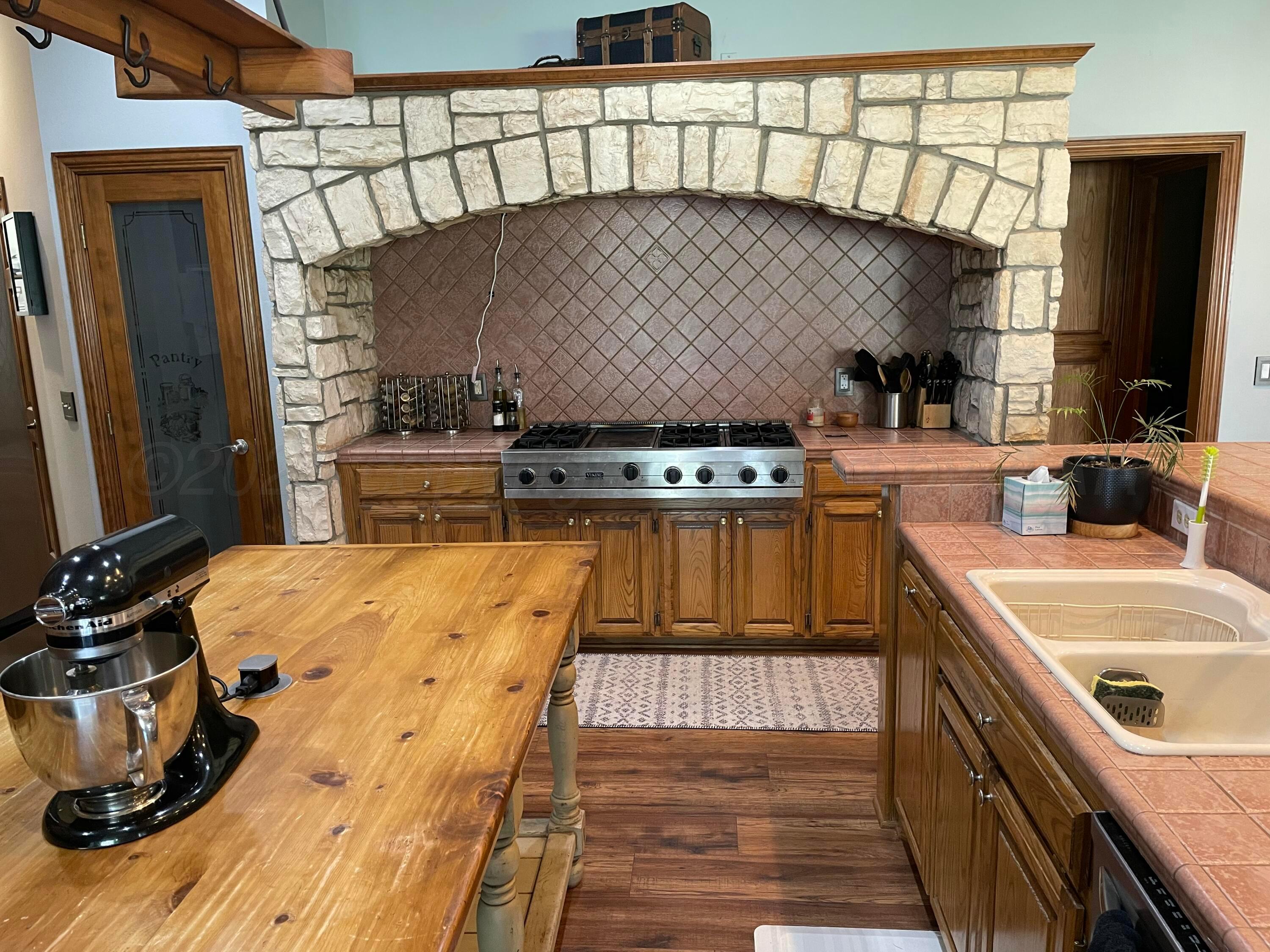 7 Pebble Beach Court Amarillo, TX 79124 - Photo 10 of 67 a kitchen with a stove a sink and a wooden floor