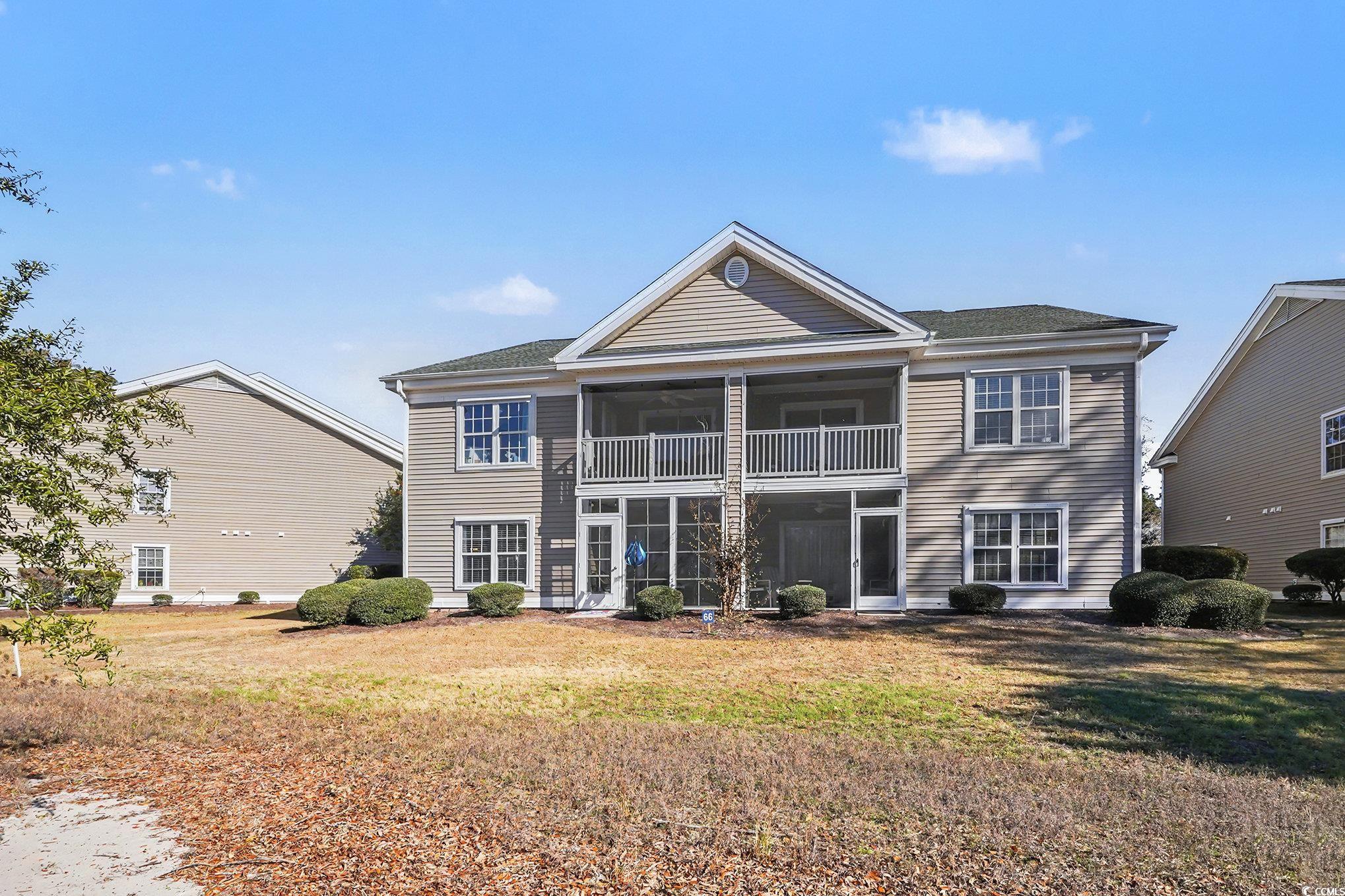 725 Blue Stem Drive, Unit 66B Pawleys Island, SC 29585 - Photo 25 of 30 Back of house with a sunroom, a yard, and a balcony
