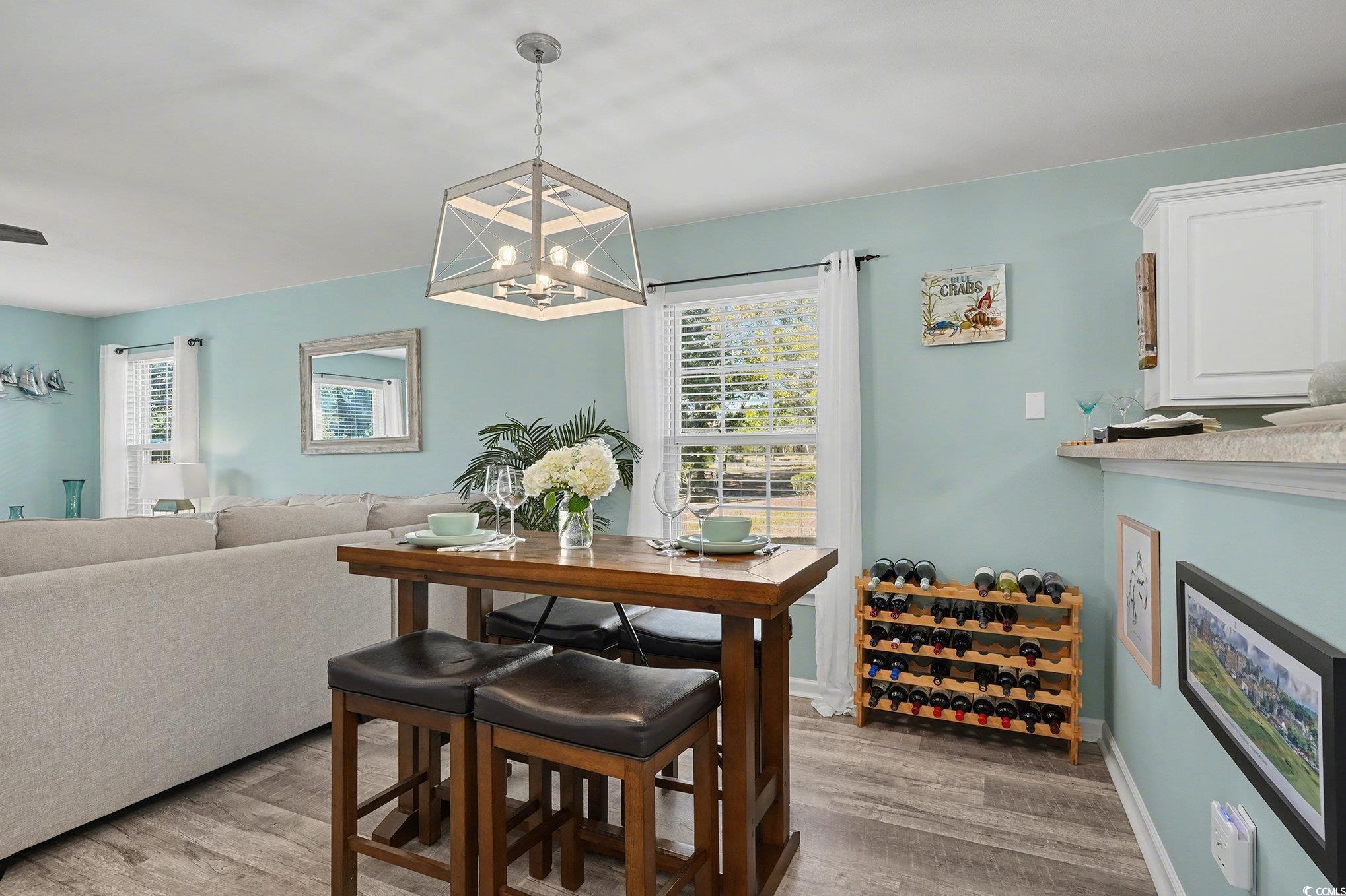 725 Blue Stem Drive, Unit 66B Pawleys Island, SC 29585 - Photo 4 of 30 Dining space with light wood-style floors and a chandelier