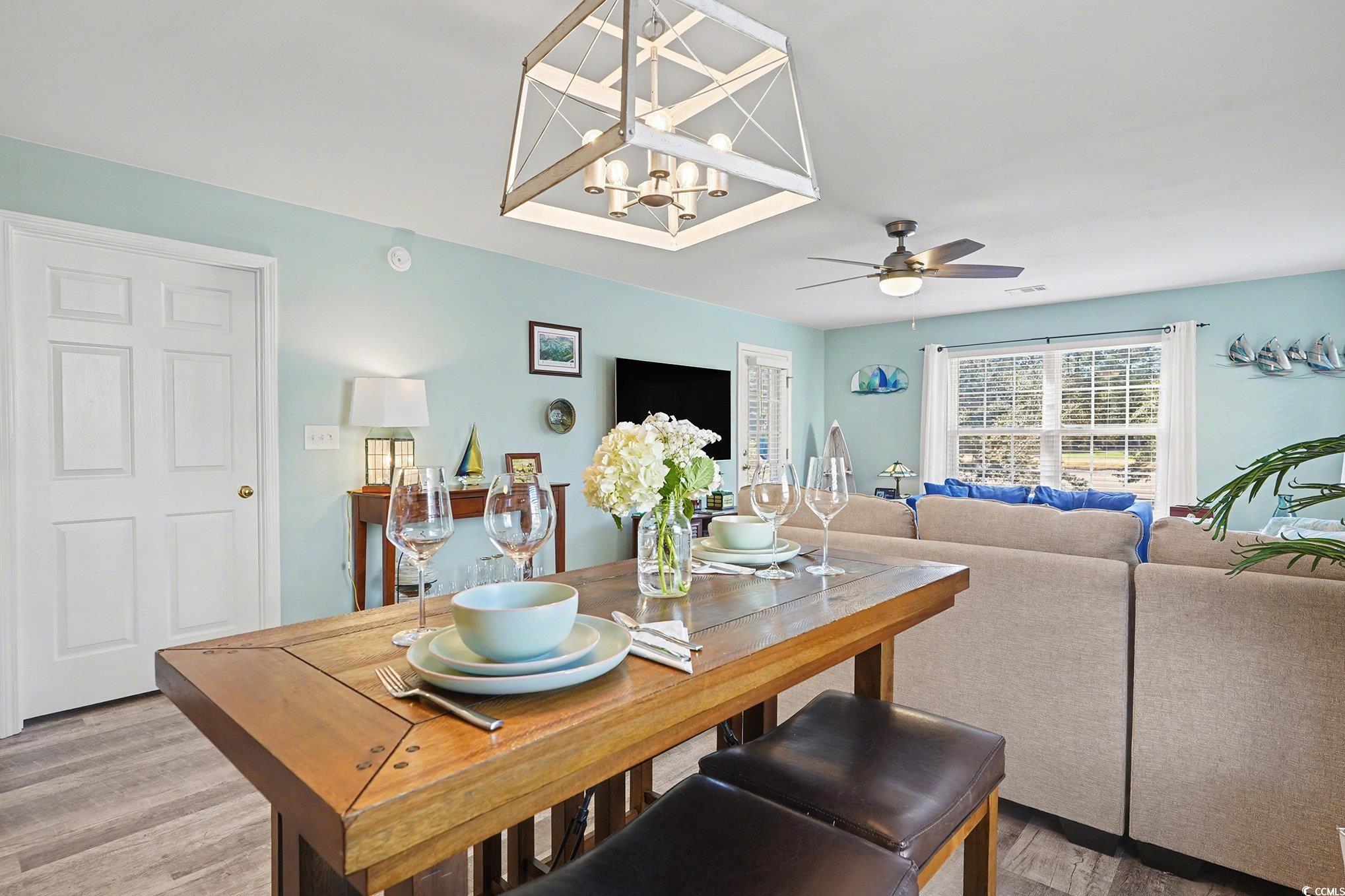 725 Blue Stem Drive, Unit 66B Pawleys Island, SC 29585 - Photo 6 of 30 Dining space featuring a chandelier, wood finished floors, and a ceiling fan