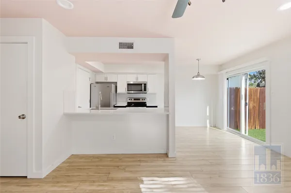 a view of kitchen living space with wooden floor and electronic appliances