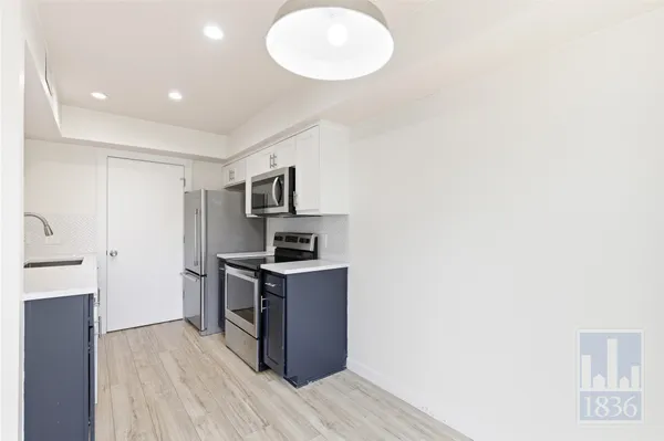 a kitchen with stainless steel appliances a stove refrigerator and a microwave