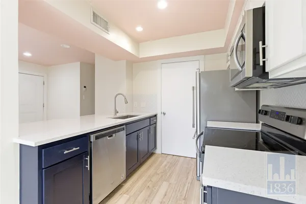 a kitchen with stainless steel appliances a sink and a refrigerator