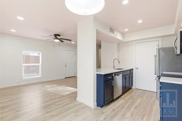 a kitchen with stainless steel appliances granite countertop a sink and a refrigerator