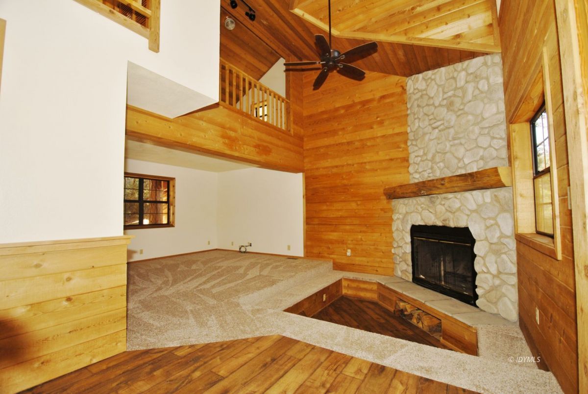 26720 Saunders Meadow Road Idyllwild, CA 92549 - Photo 7 of 65 a view of an empty room with wooden floor and a fireplace