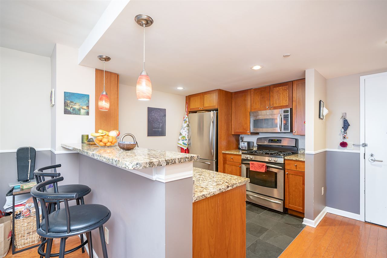 700 Grove Street, Unit 4V Jersey City, NJ 07310 - Photo 1 of 25 a kitchen with stainless steel appliances granite countertop a sink stove and refrigerator