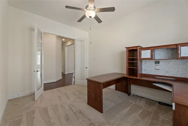 a spacious bedroom with a bed and a ceiling fan