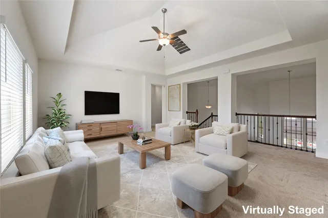 a living room with furniture and a ceiling fan