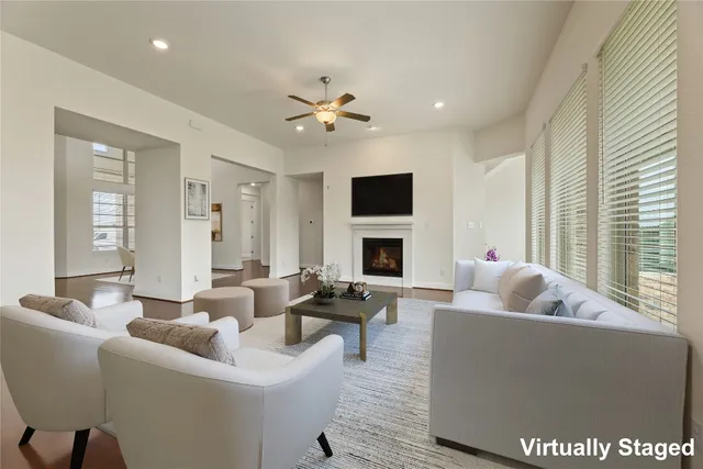 a living room with furniture ceiling fan and a window