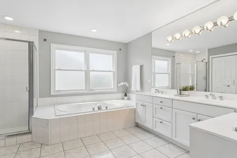 a bathroom with a tub a sink and mirror