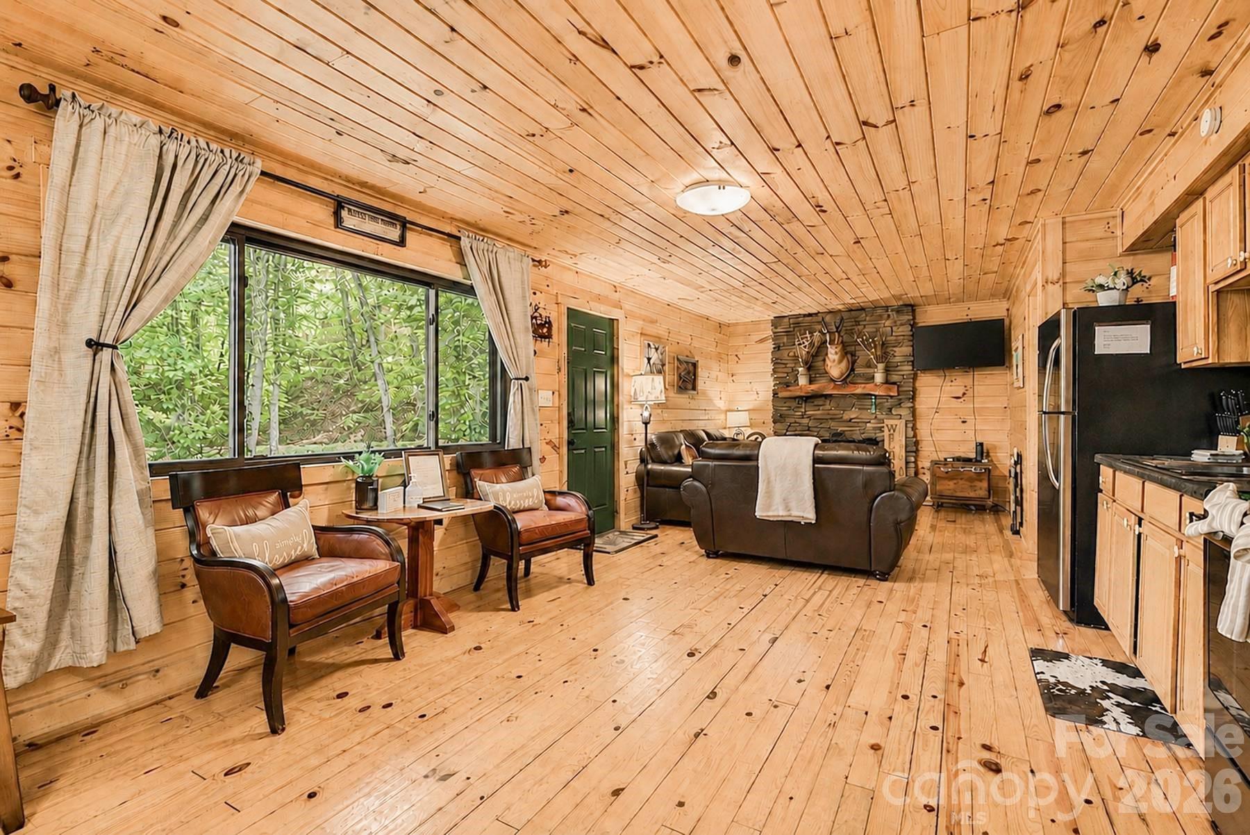 319 Blue Ridge Parkway, Unit 53 Bryson City, NC 28713 - Photo 3 of 22 a living room with furniture a flat screen tv and a floor to ceiling window
