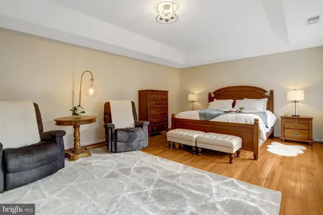 a spacious bedroom with a bed and dresser