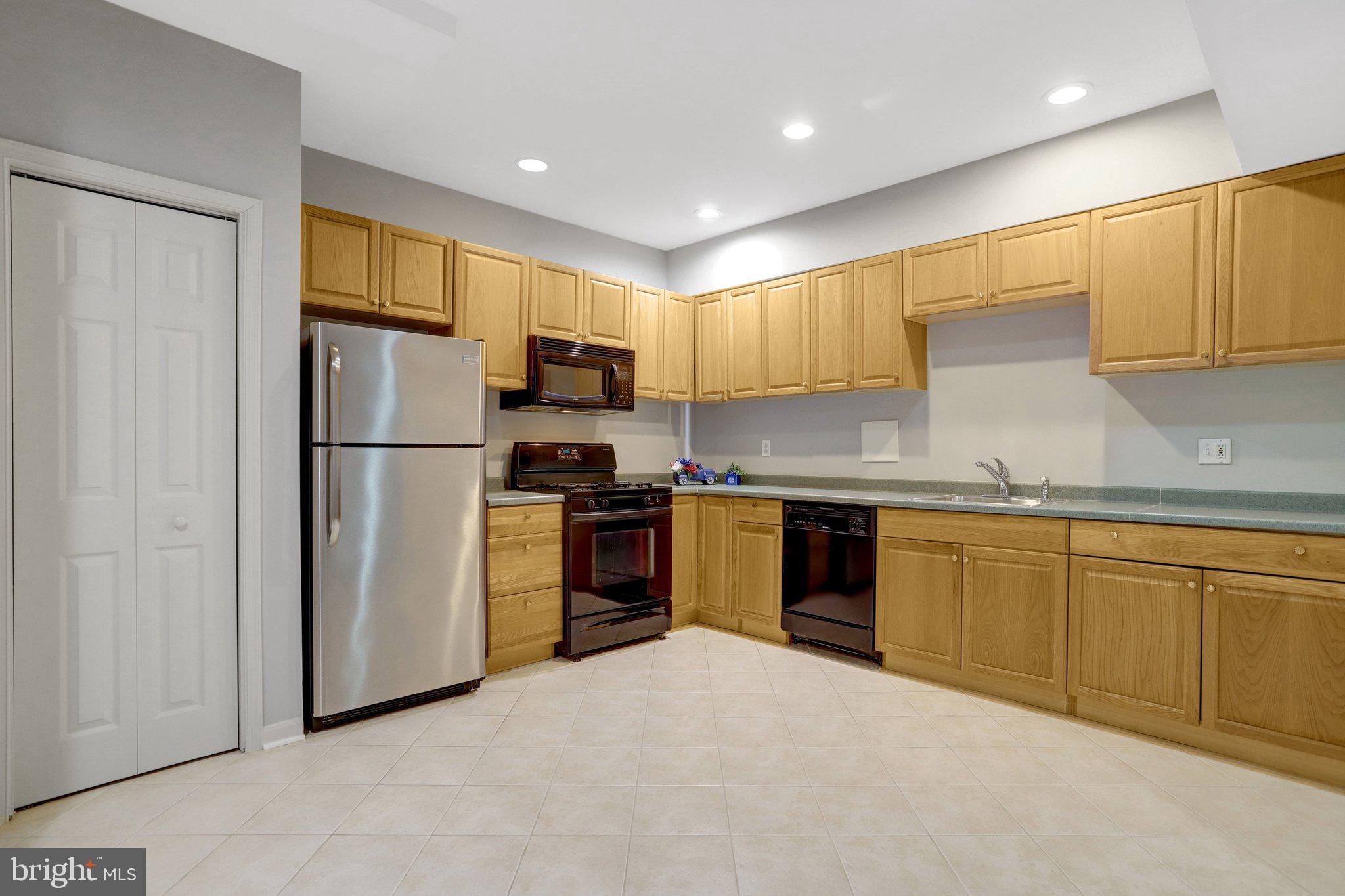 7374 Pohick Ridge Court Springfield, VA 22153 - Photo 46 of 58 a kitchen with granite countertop stainless steel appliances a refrigerator sink and microwave