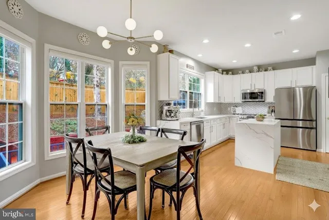 a kitchen with a sink a refrigerator a window and cabinets